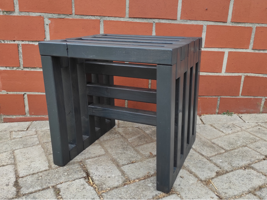 Ein kleiner Hocker aus dunklem Holz