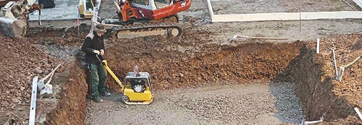 Baugrube mit Kies und Rüttelplatte