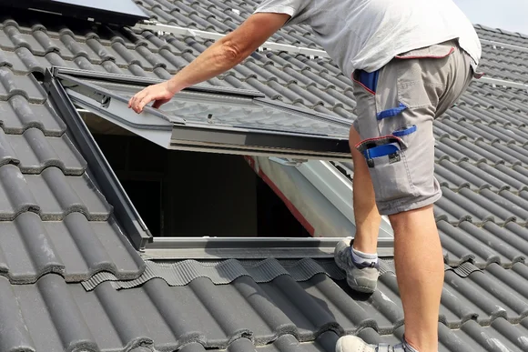 Person montiert Dachfenster.