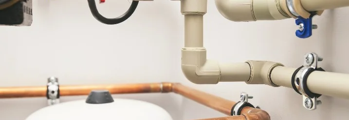 Kupfer- und Kunststoffrohre an Wand