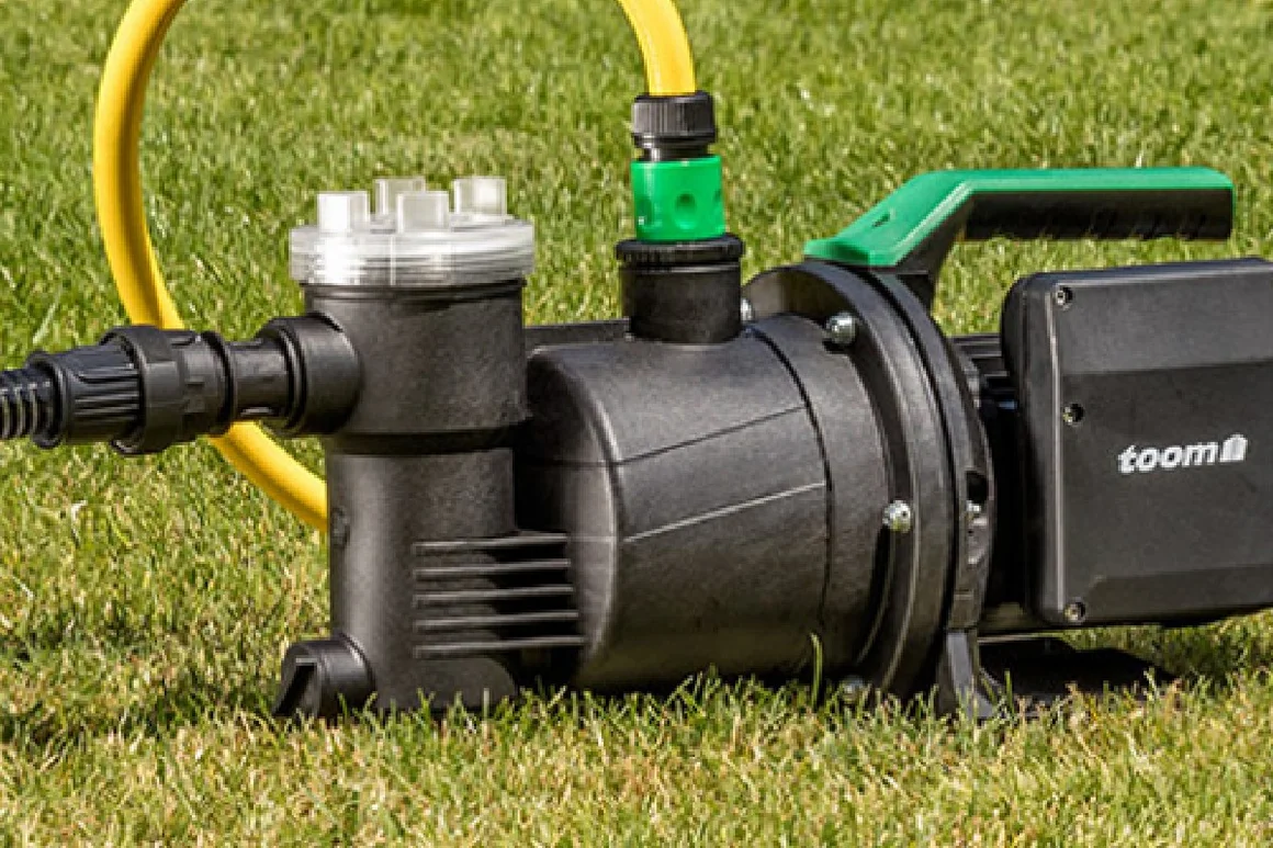 Schwarze Gartenpumpe auf Rasen