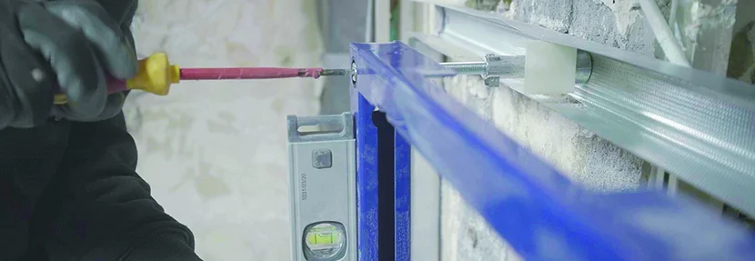 Person montiert Metallrahmen mit Wasserwaage