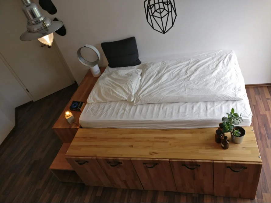 Hochbett aus hellem Holz mit weißer Bettwäsche