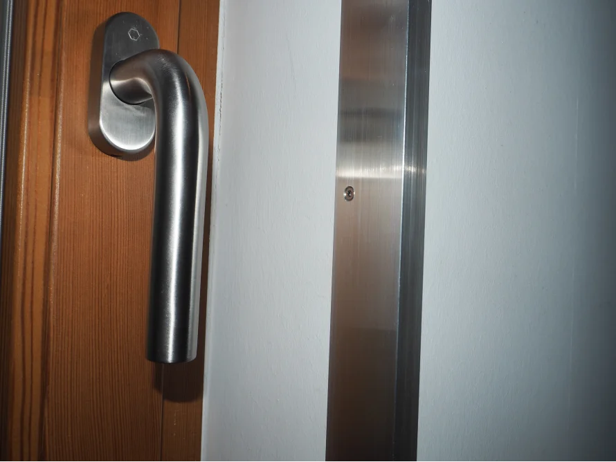 Fenstergriff aus Metall an einem Holzfenster