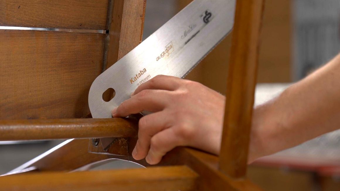 Person sägt Holz mit Säge