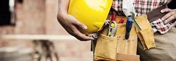 Person mit Bauhelm und Werkzeug