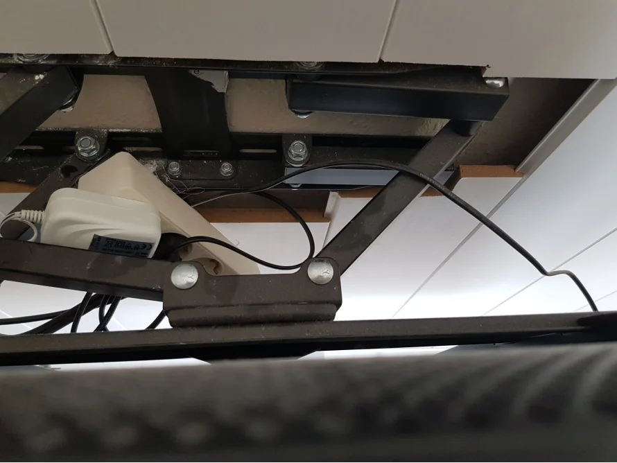 Unterseite eines Bettgestells mit Kabeln