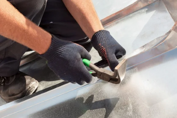 Person biegt Blech mit Zange