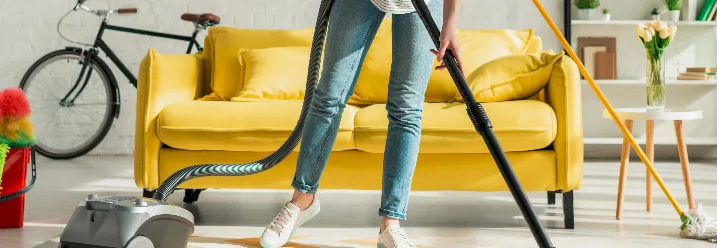 Person staubsaugt einen Teppich.