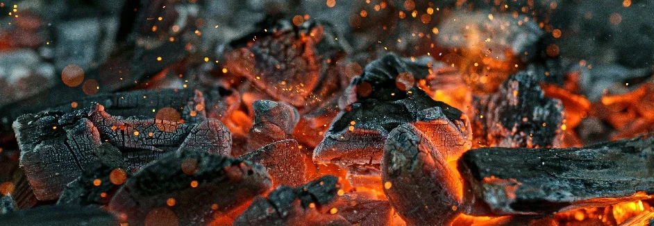 Glühende Holzkohlestücke im Feuer