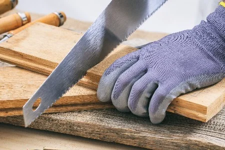 Hand sägt Holz mit Säge