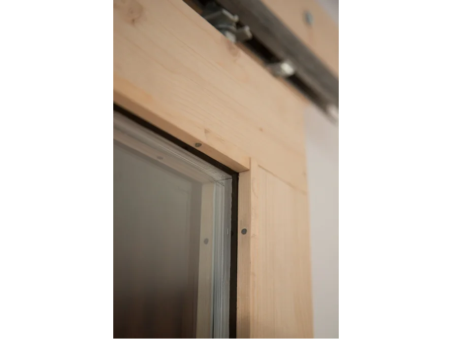 Ecke einer Holzschiebetür mit Glasscheibe