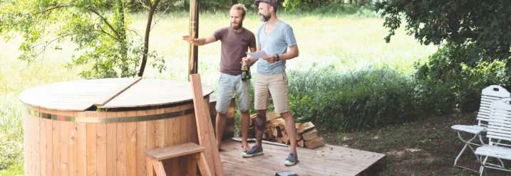 Zwei Personen bauen einen Whirlpool aus Holz