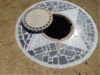 Offener Kanalisationsschacht mit Mosaikmuster