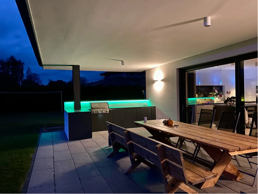 Moderne Außenküche mit Grill bei Nacht