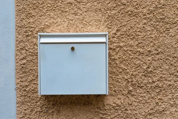 Weißer Briefkasten an Hauswand