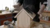 Person baut ein Vogelhaus aus Holz