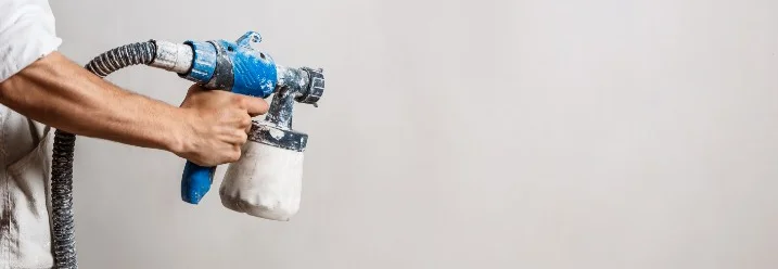 Person hält eine Farbspritzpistole