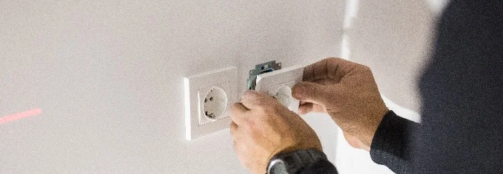 Person montiert eine Steckdose.