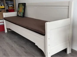 Weiße Holzbank mit braunem Polster