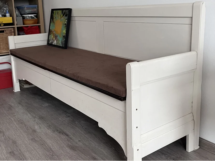 Weiße Holzbank mit braunem Polster