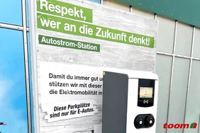 Ladesäule vor toom-Plakat