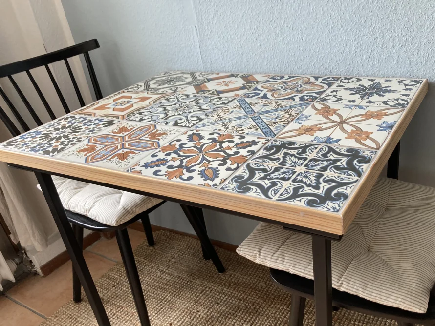 Tisch mit Fliesenmuster und zwei Stühlen