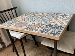 Tisch mit Fliesenmuster und zwei Stühlen