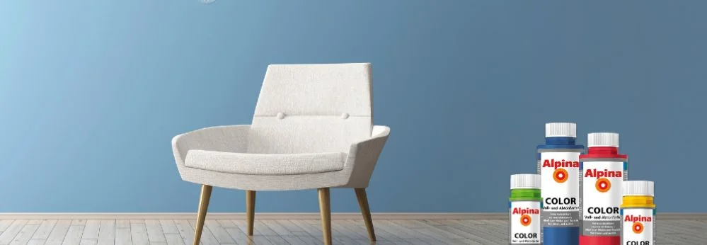 Sessel in blau gestrichenem Zimmer, Farbflaschen