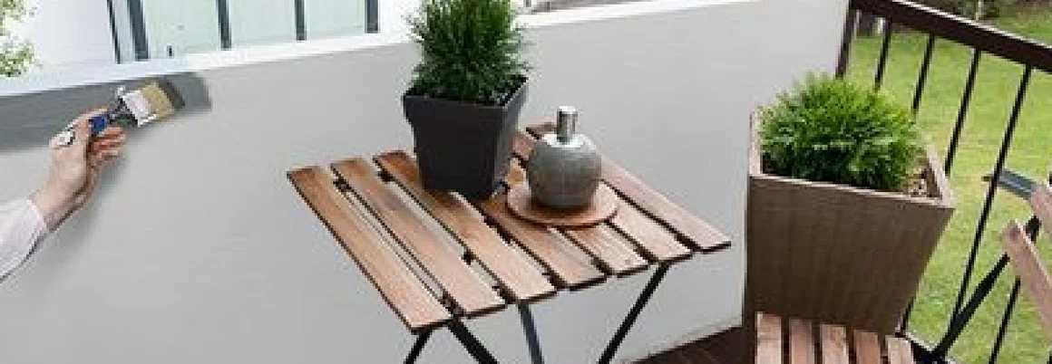 Person streicht Balkonbrüstung