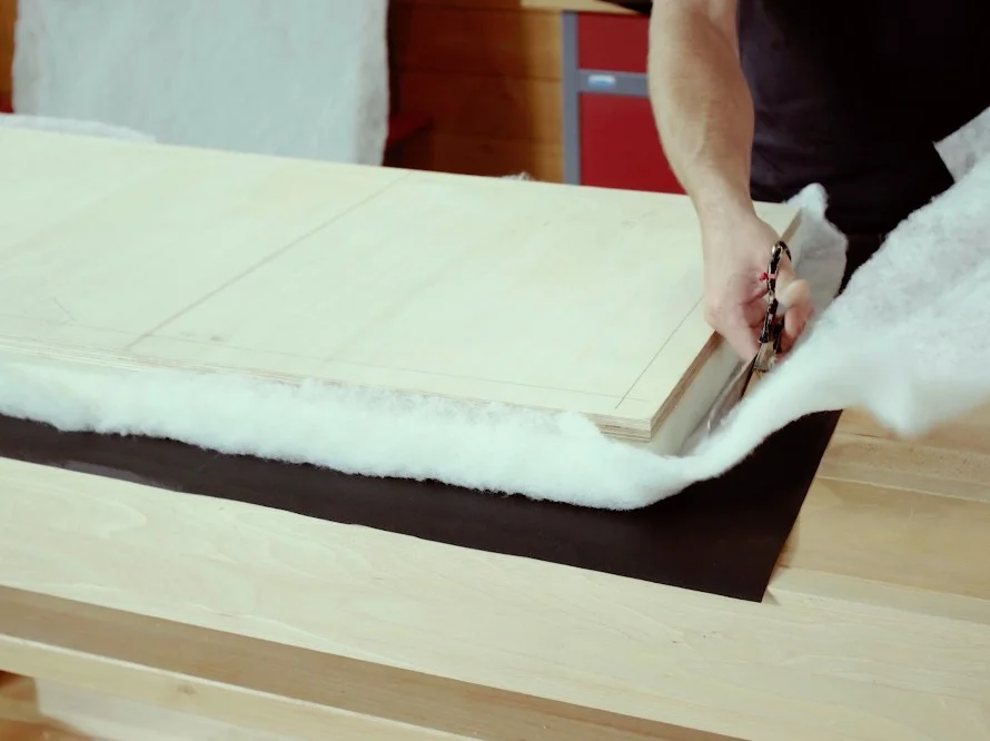 Person schneidet Polsterwatte mit Schere