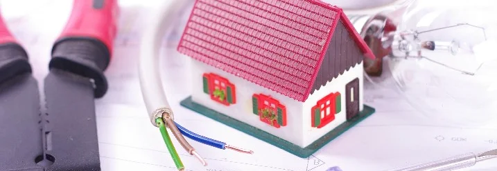 Hausmodell, Kabel, Glühbirne und Werkzeug