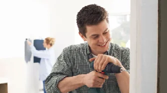 Person bohrt mit Akkuschrauber in Wand