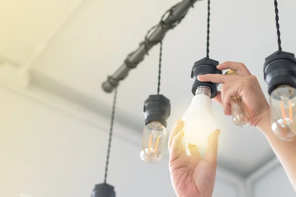 Person schraubt Glühbirne ein