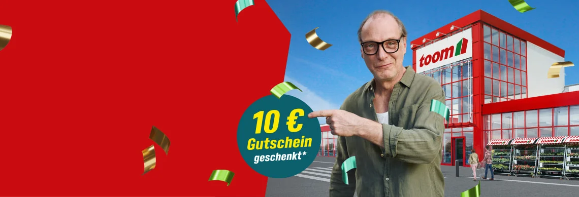 Person zeigt lächelnd auf einen 10€ Gutschein vor einem Baumarkt.