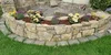 Eine geschwungene Trockenmauer als Hochbeet mit Blumenbepflanzung.