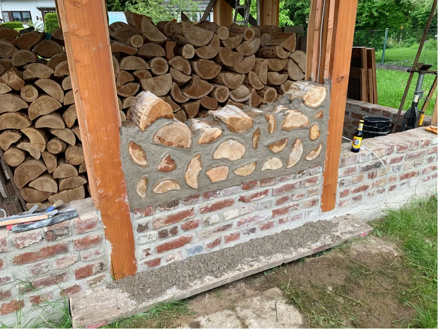 Holzstapel an Backsteinmauer