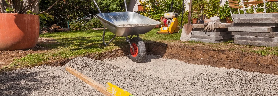 Schotterfläche mit Wasserwaage und Schubkarre