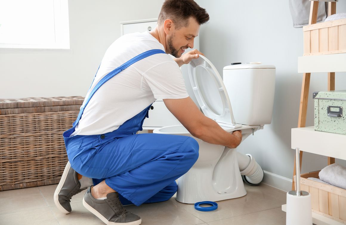 Handwerker im Bad montiert WC