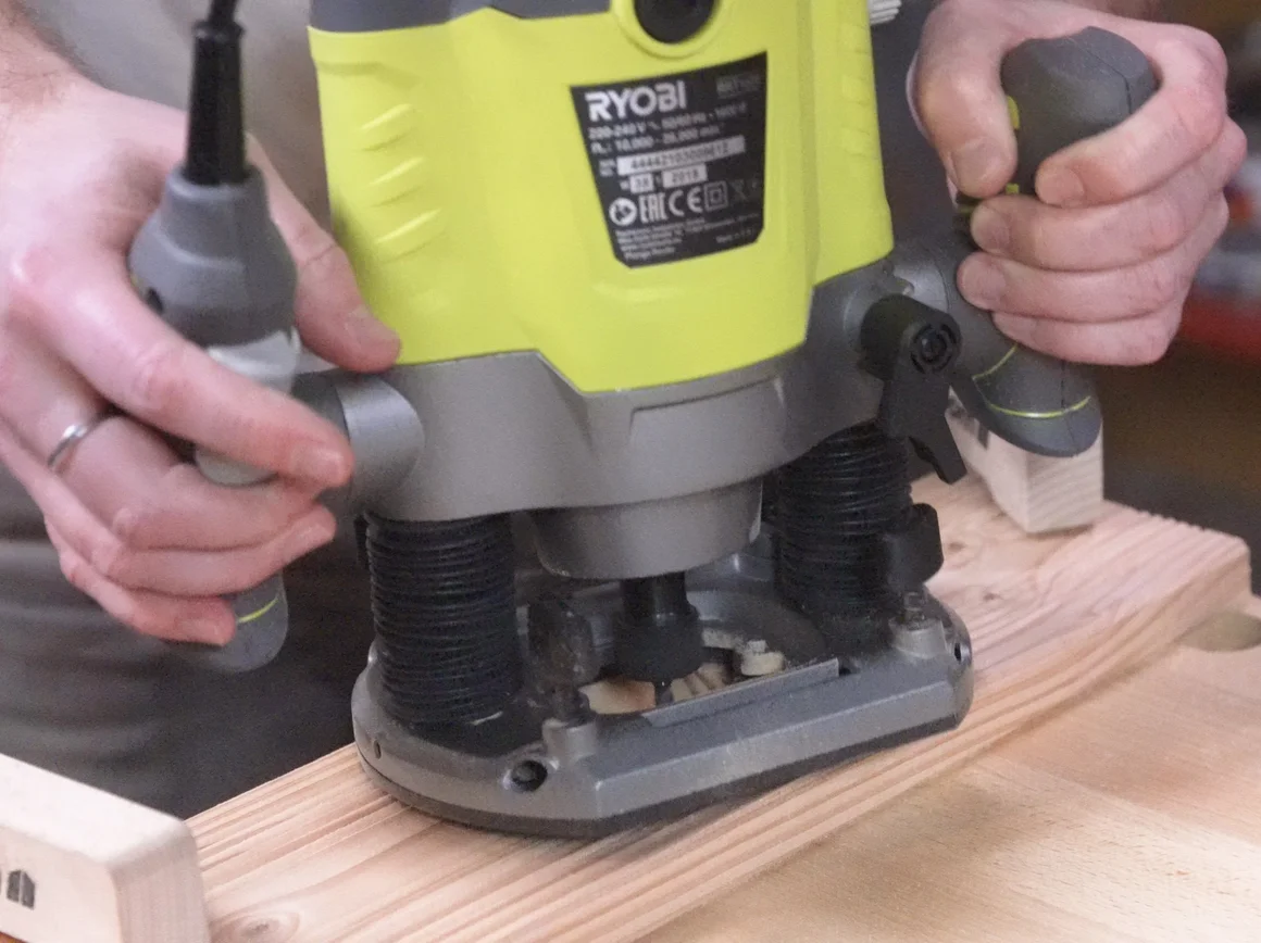 Person verwendet Oberfräse auf Holzbrett