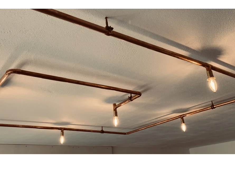 Industrielle Deckenbeleuchtung aus Kupferrohren