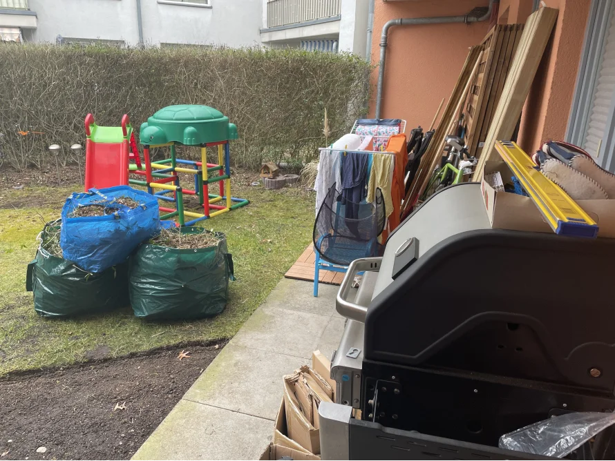 Unordentlicher Garten mit Spielzeug und Gartengeräten