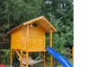Hölzernes Spielhaus mit blauer Rutsche und Hängematte