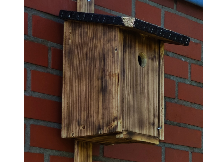 Ein brauner Vogelhaus aus Holz.