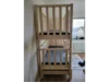 Ein Hochbett aus hellem Holz mit zwei übereinander liegenden Betten.