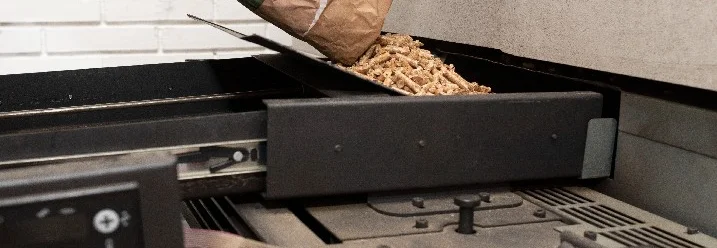 Person befüllt Pelletofen