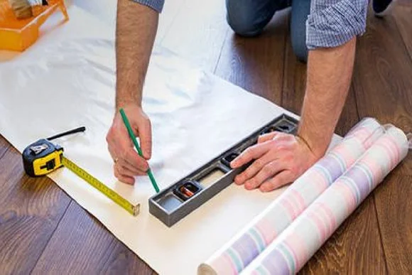 Person verwendet Wasserwaage und Metermaß