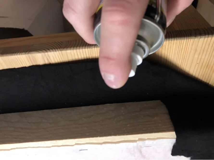 Person sprüht auf schwarzen Stoff