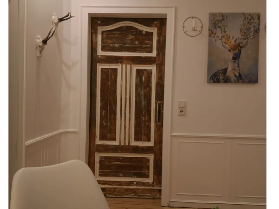 Rustikale Holztür mit Geweih an der Wand