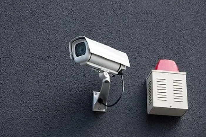 Überwachungskamera und Alarmsirene an Wand